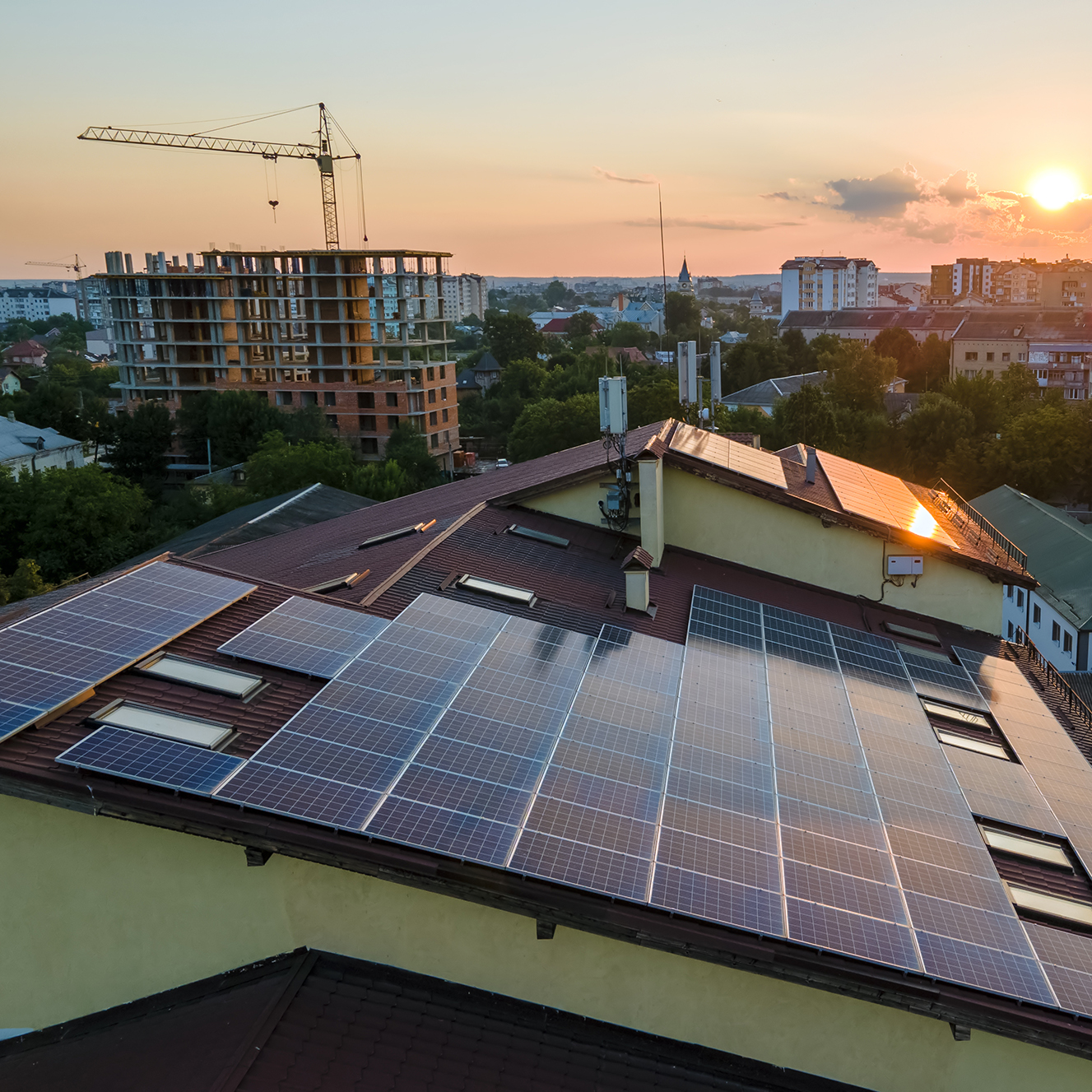 blue-photovoltaic-solar-panels-mounted-on-building-roof-for-producing-clean-ecological-electricity-at-sunset-production-of-renewable-energy-concept